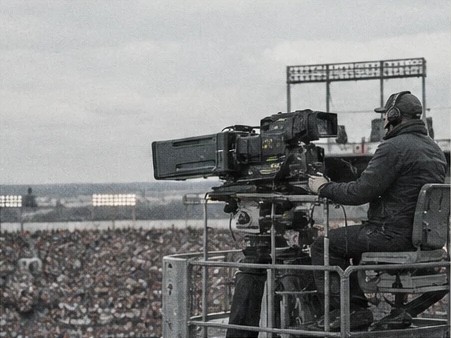 Broadcast camera operator on a raised stadium camera platform