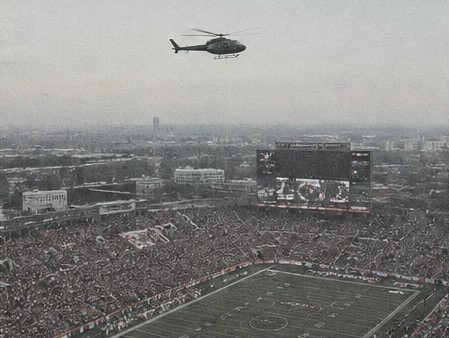 Helicopter flying over a packed football stadium